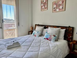 a bedroom with a large white bed with pillows and a window at TRA CIELO e MARE da VALE in Fano