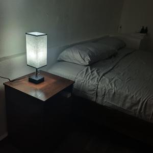 a lamp on a table next to a bed at Loft Garden Santiago México in Santiago