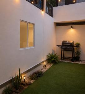 a backyard with a grill on the side of a house at Loft Garden Santiago México in Santiago