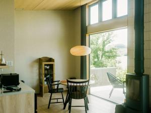 a dining room with a table and chairs and a window at HOTEL & KOTEI SOKA in Kyotango