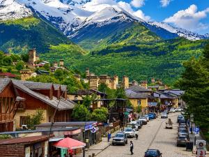 a street in a town with mountains in the background at Daeli Hotel in Mestia