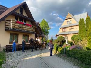 a horse drawn carriage in front of a house at Kapacówka in Zakopane