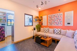 a living room with orange walls and a white couch at Footprint Hostel Udaipur in Udaipur
