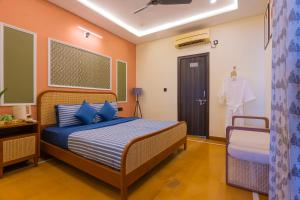 a bedroom with a bed with blue pillows and a door at Footprint Hostel Udaipur in Udaipur