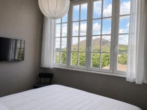 a bedroom with a bed and a large window at The Brewhouse Hotel in Edinburgh