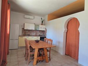a small kitchen with a wooden table and chairs at Villa Patrizia in Taviano +17 photos