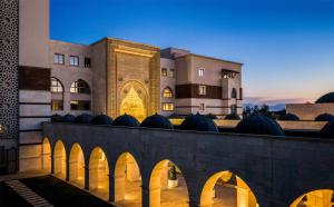 a building with a bridge in front of it at Kempinski Hotel The Dome Belek in Belek