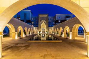 a mosque with a fountain in a courtyard at night at Kempinski Hotel The Dome Belek in Belek