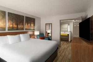 a hotel room with a bed and a flat screen tv at Days Inn by Wyndham Clanton AL in Clanton