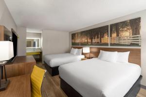 a hotel room with two beds and a television at Days Inn by Wyndham Clanton AL in Clanton +35 photos