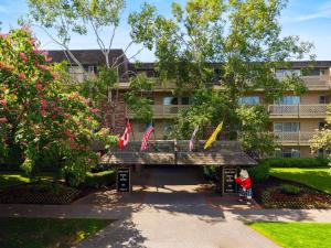 a building with flags in a park with a bench at Royal Scot Hotel & Suites, Trademark Collection by Wyndham in Victoria