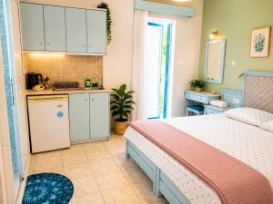 a bedroom with a bed and a small kitchen at Klima Rooms in Palaiochora