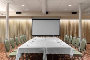 a conference room with a table and chairs and a screen at Royal Scot Hotel & Suites, Trademark Collection by Wyndham in Victoria +75 photos