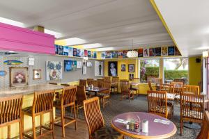 a restaurant with tables and chairs and a bar at Royal Scot Hotel & Suites, Trademark Collection by Wyndham in Victoria