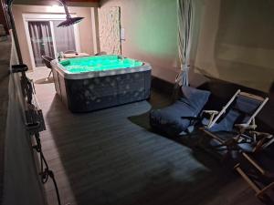 a hot tub in a room with two chairs and a table at Peter's Place Studios & Suites in Faliraki
