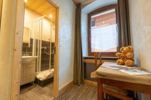 a teddy bear sitting on a table in a bathroom at Hotel la Pointe Percee in Le Grand-Bornand