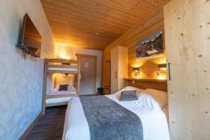 a bedroom with a large bed in a wooden room at Hotel la Pointe Percee in Le Grand-Bornand
