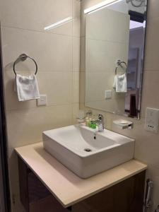 a bathroom with a white sink and a mirror at Ocean Breeze Residencies in Negombo