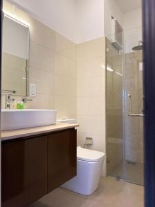 a bathroom with a toilet and a sink and a shower at Ocean Breeze Residencies in Negombo