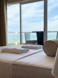 a bedroom with a bed with a large window at Ocean Breeze Residencies in Negombo