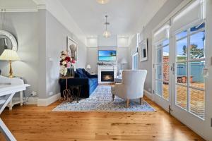 a living room with a blue couch and a fireplace at Roseberne Cottage, Luxury in the CBD! in Bathurst