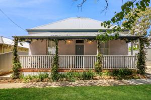a house with a white fence and a porch at Roseberne Cottage, Luxury in the CBD! in Bathurst
