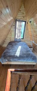 a bed in a wooden room with a window at Cottage Sunset 2 in Sakhalvasho