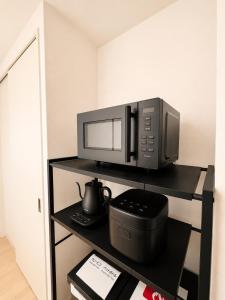 a microwave sitting on a shelf in a room at Residence Hotel Liberte in Sapporo +10 photos