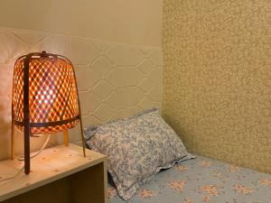 a room with a bed with a lamp and a pillow at 신사 여성전용 개인 미니룸 Female Only Private Mini Room Gosiwon 2pm ckeck in 11am ckeck out address 강남구 논현동6-8 BESTEL, Check the message for the check in in Seoul