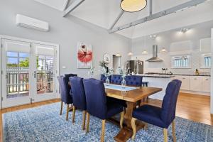 a kitchen and dining room with a wooden table and blue chairs at Roseberne Cottage, Luxury in the CBD! in Bathurst +11 photos
