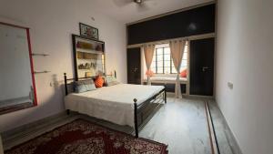 a bedroom with a bed and a large window at Hardik villa in Udaipur