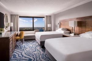 a hotel room with two beds and a couch at Hyatt Regency Orlando in Orlando