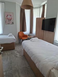 a hotel room with two beds and a flat screen tv at Enza Suites in Shumen +35 photos