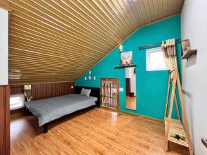 a room with a bed and a blue wall at TeeDalat House in Khu Chi Lăng