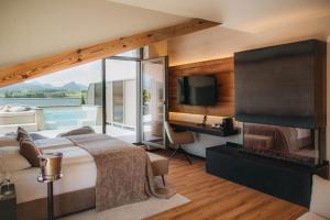 a bedroom with a bed with a fireplace and a television at Hotel am Hopfensee in Füssen