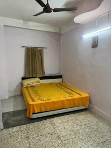 a bed in a room with a ceiling fan at Gem Backpackers Hostel in Siliguri