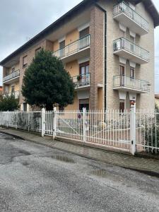 a white picket fence in front of a building at San Francisco in Borgo San Dalmazzo