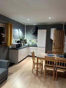a kitchen and dining room with a table and chairs at Domki z Widokiem in Radków