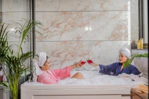 two women sitting in a bath tub withwine at Stay XO - A Luxurious 3BHK Villa in Panchkula in Panchkula +41 photos
