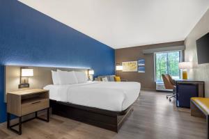 a bedroom with a large bed and a blue wall at Comfort Inn West Hazleton in West Hazleton +42 photos