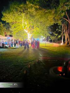 a group of people standing in a park at night at Hotel Kamrel Sigiriya in Sigiriya +145 photos