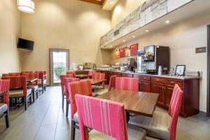 a restaurant with tables and chairs and a bar at Comfort Suites at Par 4 Resort in Waupaca