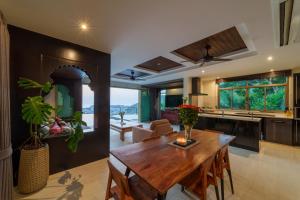 a kitchen and living room with a wooden table at Villa 18 Kata-Private Pool Villa with Sea View in Ban Kata