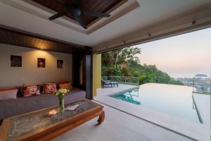 a living room with a couch and a swimming pool at Villa 18 Kata-Private Pool Villa with Sea View in Ban Kata