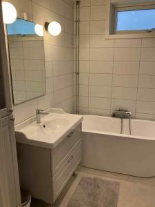 a bathroom with a sink and a tub and a mirror at Bergnäset in Luleå +5 photos