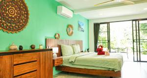 a bedroom with a bed with a red stuffed animal on it at Villa des Princes in Ban Thung