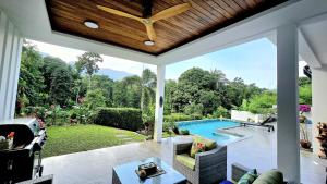 a living room with a view of a swimming pool at Villa des Princes in Ban Thung
