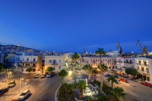 a city with buildings and palm trees at night at Arxontissa Rooms in Ermoupoli