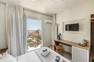 a room with a desk and a window with a view at Arxontissa Rooms in Ermoupoli