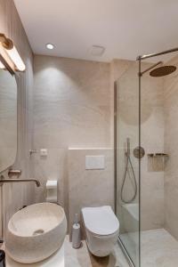 a bathroom with a toilet and a glass shower at Arxontissa Rooms in Ermoupoli +14 photos